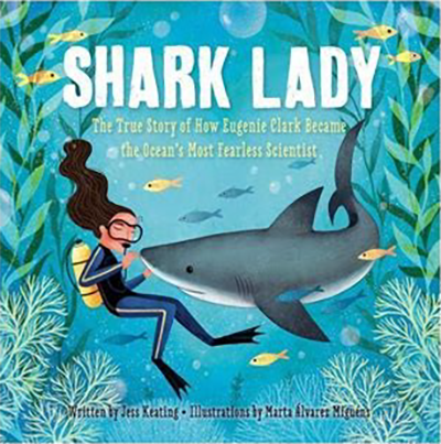 Book cover for Shark Lady. Illustration of a woman with long dark hair wearing a diving suit underwater near a shark.