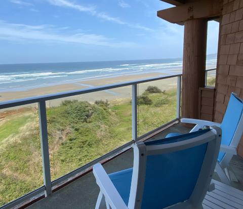 A view of a balcony overlooking the ocean and beach. 