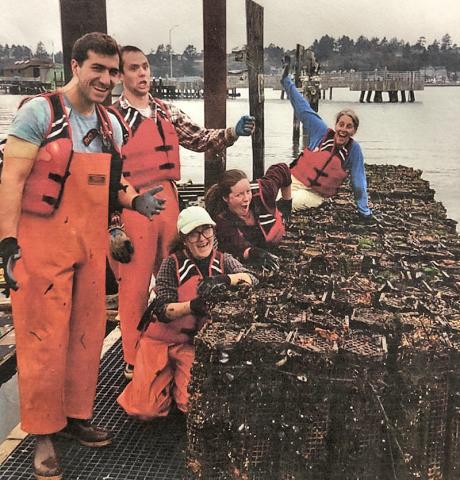 Research team for MBP in orange waders and lifevest pose with silly faces on a pier.