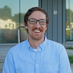 A man with red hair and glasses.
