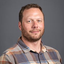 A man with a brown beard and short brown hair.