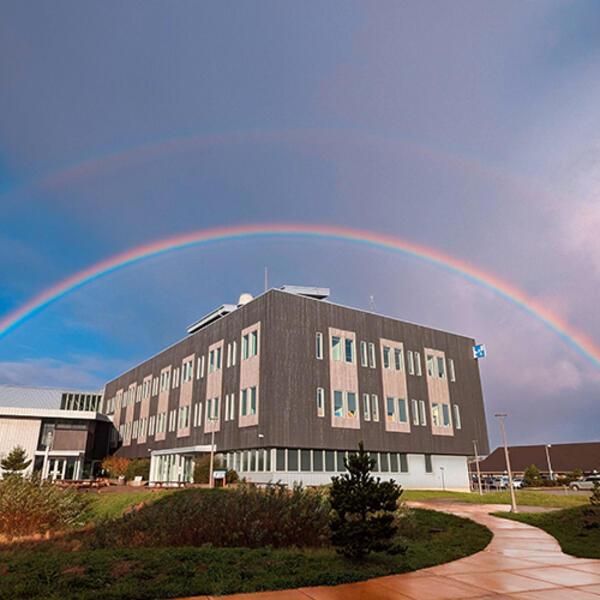 A rainbow arches over a building.
