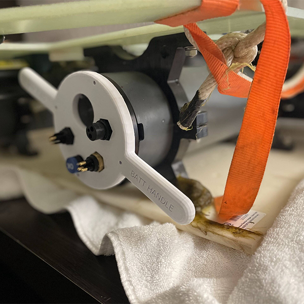 A gray plastics handle on an engine.